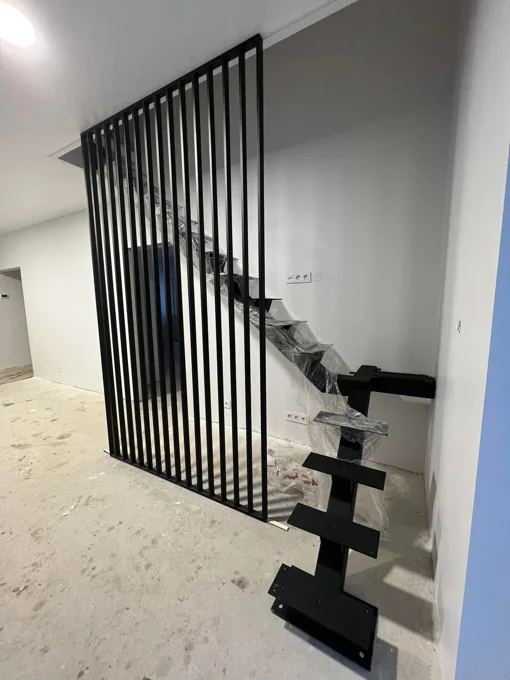 Vertikalūs juodi turėklai prie nebaigtų laiptų